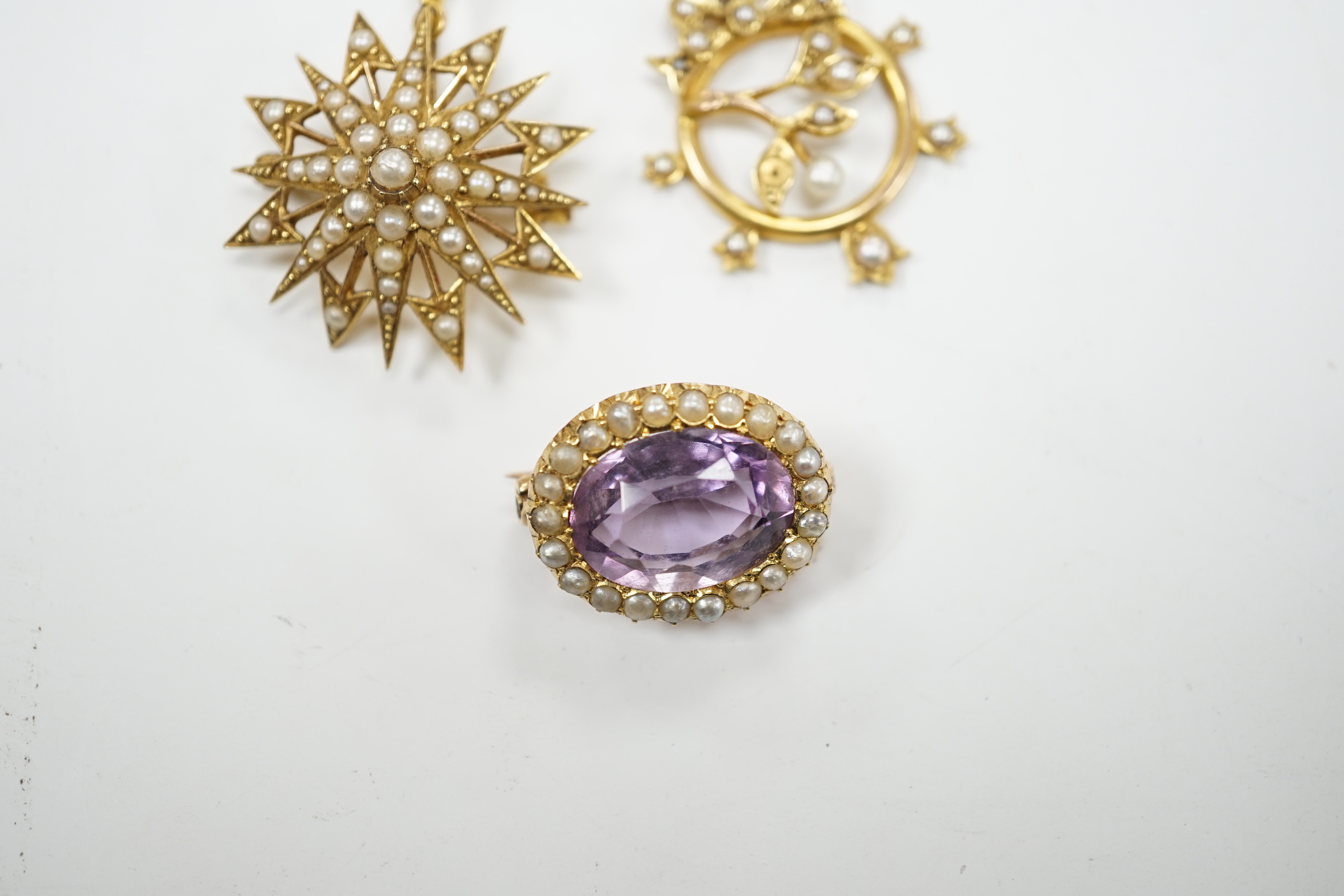 A Victorian 15ct, amethyst and seed pearl foliate pendant and a similar yellow metal and seed pearl set starburst pendant, gross weight 10.6 grams.